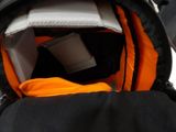 a black and orange backpack with a cup inside of it