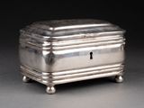 a silver box with a key on it on a table