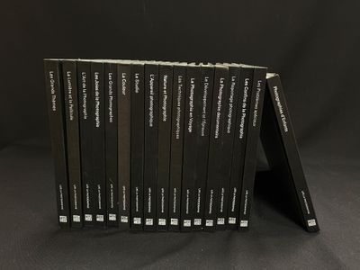 six livres alignés sur une surface noire avec un fond noir