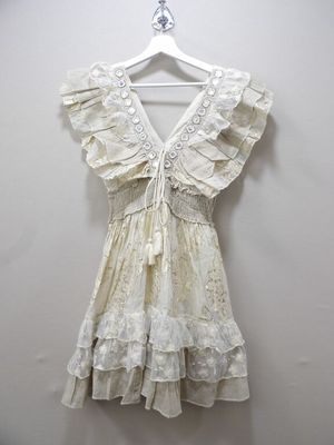 white dress hanging on a hanger against a white wall