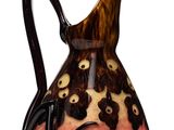 a brown and black vase with a black handle on a white surface