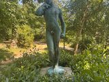 une statue au milieu d'un champ verdoyant