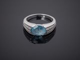a close up of a ring with a blue stone on a black surface