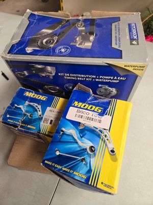 trois boîtes de pièces de moteur posées sur une table