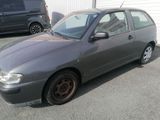 a grey car parked in a parking lot next to a building