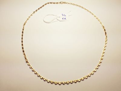 a close up of a gold necklace on a white surface