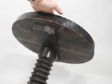 a hand that is holding a wooden object on top of a table