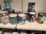 de nombreux pots de peinture posés sur une étagère dans une pièce