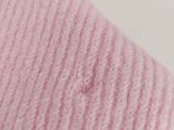 the pink blanket is laying on a white surface