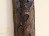 a wooden carving of a woman with a bird on her shoulder