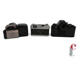 three cameras sitting next to each other on a white surface