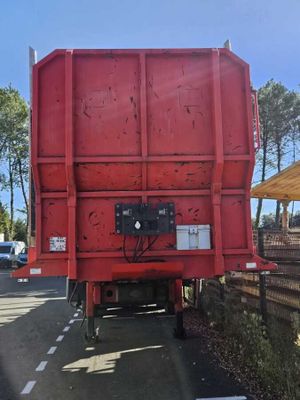un camion-benne rouge garé sur le bord de la route
