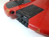 underside view of a red electric guitar with a black back panel