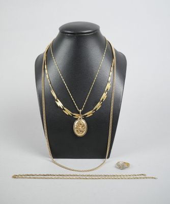 a gold necklace with a coin and a chain on a mannequin