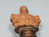 a sculpture of a bust on a wooden post on a wall