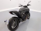 a black motorcycle parked in a room with white walls