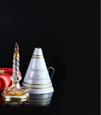 bottles of perfume and a candle on a table with a black background