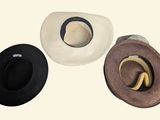 three hats sitting on top of each other on a white surface