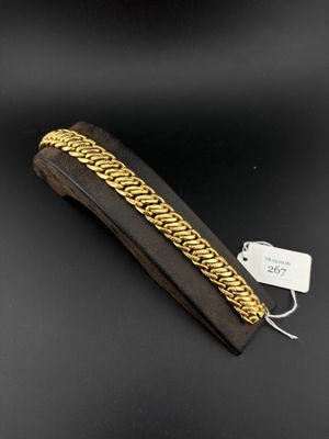 a close up of a gold chain bracelet on a black background