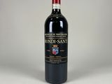 the bottle of red wine is sitting on a white surface
