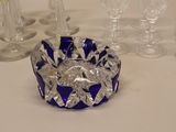 a blue glass ashtray sitting on a table next to wine glasses