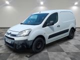 la camionnette blanche est garée dans une pièce au sol en damier