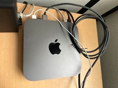 an apple mac mini computer sitting on top of a wooden desk