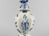 blue and white vase with a bird on top of it