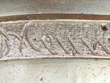 a close up of a silver vase with writing on it