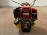 a small red and yellow lawn mower sitting on the floor