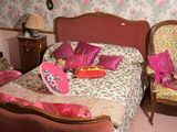 un lit et une chaise dans une pièce dont l'un des murs est recouvert de papier peint