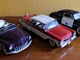 trois petites voitures posées sur une table