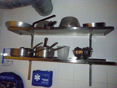 de nombreuses casseroles et poêles sur les étagères de la cuisine