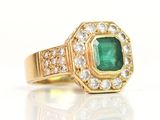an image of a close up of a gold ring with a green stone