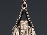 an image of a silver necklace with a cross and a wreath