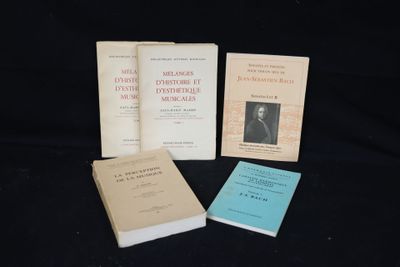 trois livres sont posés sur une surface noire, sur fond noir