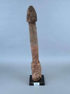 un vieil objet en bois dont l'extrémité est surmontée d'un long bâton
