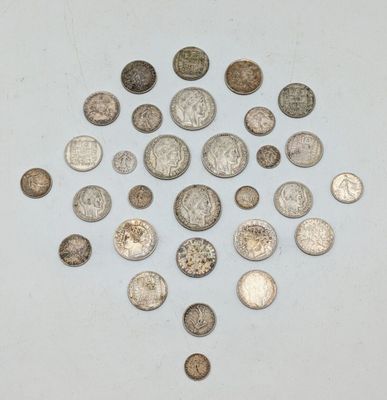 une pile de pièces d'argent posée sur une surface blanche