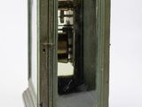 a small green cabinet with a mirror in it
