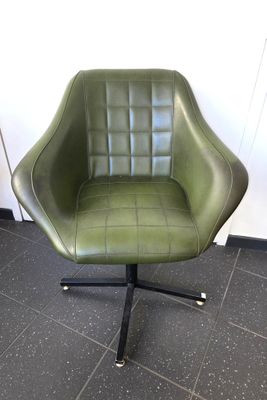 fauteuil pivotant en cuir vert, avec des pieds en métal noir et un piètement noir