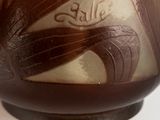 a brown vase with a design on it sitting on a table