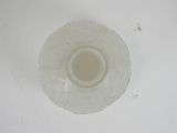 underside view of a clear glass vase with a white base