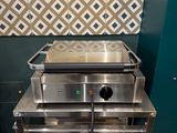 un four argenté posé sur une grille métallique