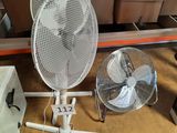 un ventilateur blanc posé à côté d'un ventilateur de table blanc