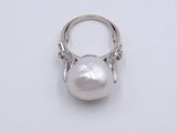 a white pearl and diamond ring on a white surface