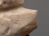 a statue of a man holding a rock with writing on it