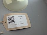 a person holding a tag with a qr code on it next to a cup of coffee