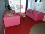 un canapé rose et un fauteuil rose dans un salon
