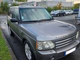 un Land Rover gris garé sur le bord de la route