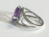 a ring with a purple stone and diamonds on it